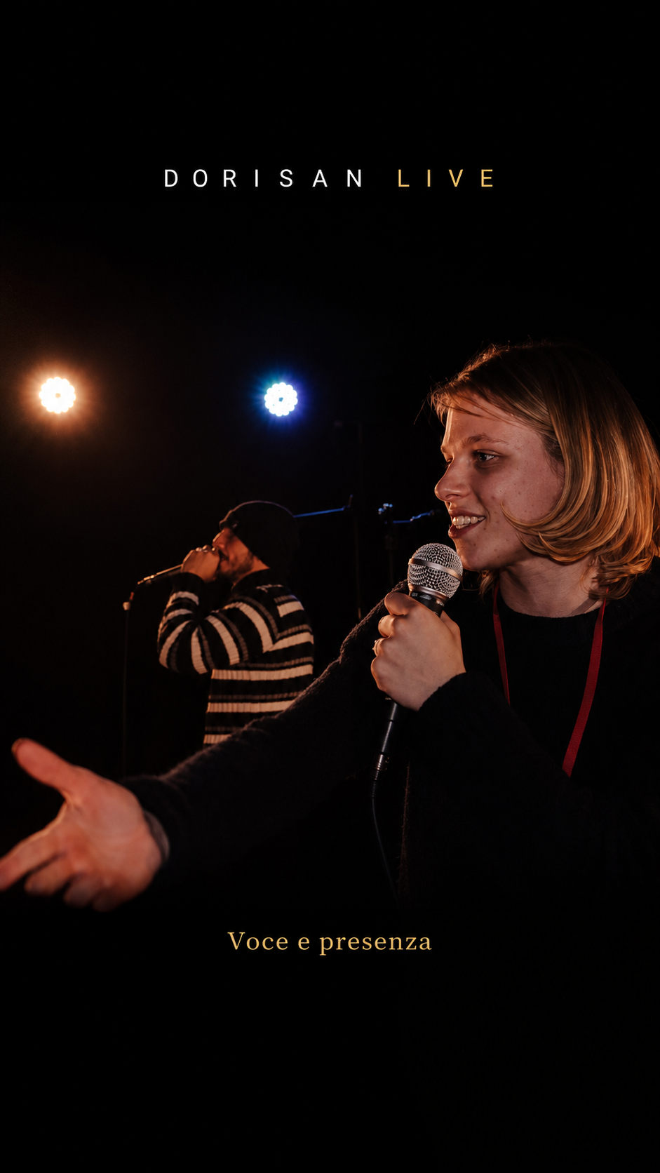 Due performer posano schiena contro schiena sul palco durante una serata dal vivo.